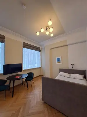 a bedroom with a bed and a table and a couch at Vydūno apartamentai 5 in Kaunas