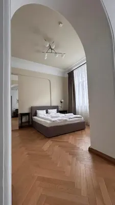 a large bedroom with a bed and a ceiling at Vydūno apartamentai in Kaunas