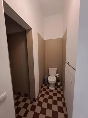 a bathroom with a toilet and a checkered floor at Vydūno apartamentai in Kaunas