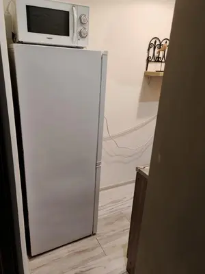 a microwave sitting on top of a refrigerator at Dviejų kambarių butas Kauno centre in Kaunas