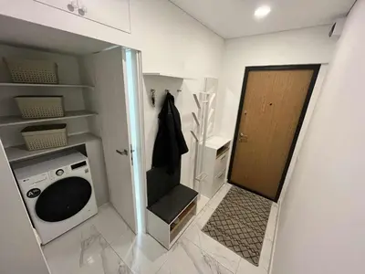 a bathroom with a washing machine and a door at Konarskio 3 kambarių butas in Vilnius