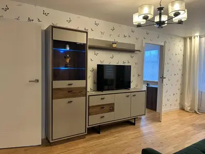 a living room with a entertainment center with a tv at Konarskio 3 kambarių butas in Vilnius