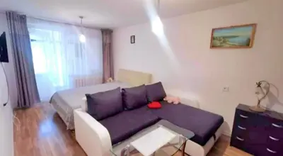 a living room with a purple couch and a bed at Butas Putinuose in Alytus