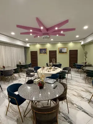 a dining room with tables and chairs and a ceiling fan at Bernotiškių Hotel & Dining