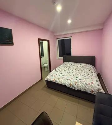a bedroom with a bed and a pink wall at Bernotiškių Hotel & Dining