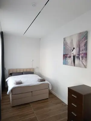 a bedroom with a bed and a painting on the wall at Park&Stay First Floor Loft Panevėžys in Panevėžys