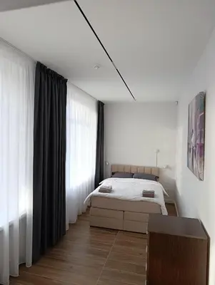 a bedroom with a bed and a large window at Park&Stay First Floor Loft Panevėžys in Panevėžys