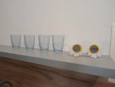 four empty glasses sitting on a table with daisies at Park&Stay First Floor Loft Panevėžys in Panevėžys