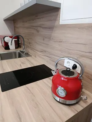 a red tea kettle sitting on a kitchen counter at Park&Stay First Floor Loft Panevėžys in Panevėžys