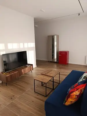 a living room with a couch and a large flat screen tv at Park&Stay First Floor Loft Panevėžys in Panevėžys