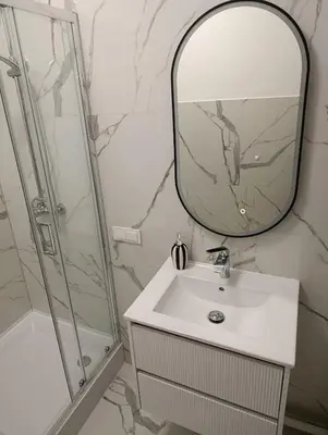 a bathroom with a sink and a mirror and a shower at Park&Stay First Floor Loft Panevėžys in Panevėžys