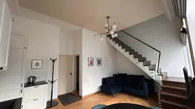 a living room with a blue couch and stairs at Vydūno apartamentai 12 in Kaunas