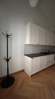 a kitchen with white cabinets and a black counter top at Vyduno apartments 9 in Kaunas