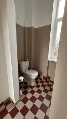 a bathroom with a toilet and a checkered floor at Vyduno apartments 9 in Kaunas