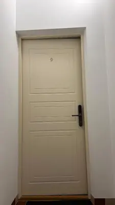 a white garage door in a corner of a room at Vyduno apartments 9 in Kaunas