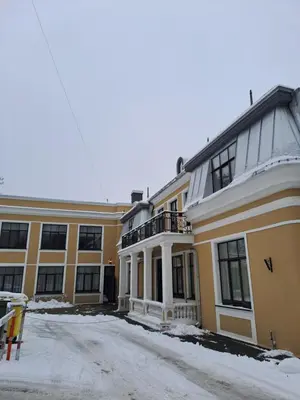 a large yellow building with a balcony in the snow at Vyduno apartments 7 in Kaunas