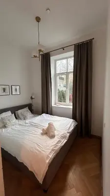 a bedroom with a white bed with a window at Historic Embassy Apartments 1 in Kaunas