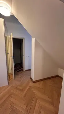 an empty room with a wooden floor and a hallway at Historic Embassy Apartments 1 in Kaunas