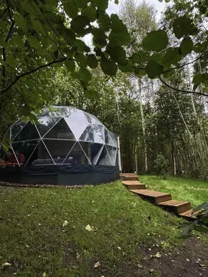a tent in the middle of a field with stairs at Tyla dviese in Kaciūniškiai