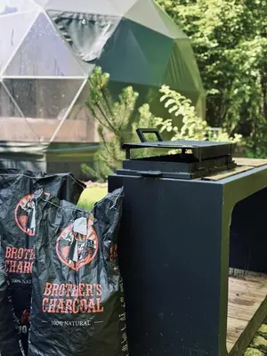 two trash bags sitting next to a trash can at Tyla dviese in Kaciūniškiai