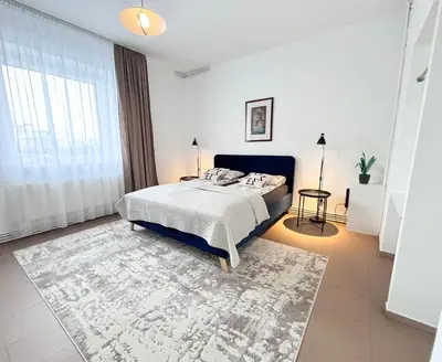 a bedroom with a bed and a large window at XXL apartamentai su nemokamu parkingu in Šiauliai