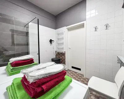 a bathroom with green and white towels on a counter at XXL apartamentai su nemokamu parkingu in Šiauliai