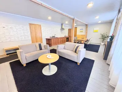 a living room with two chairs and a table at XL apartamentai su nemokamu parkingu in Šiauliai