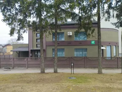 a building with trees in front of it at XL apartamentai su nemokamu parkingu in Šiauliai