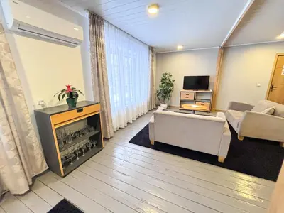 a living room with a fireplace and a couch at XL apartamentai su nemokamu parkingu in Šiauliai