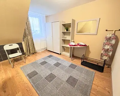 a room with a rug and a table and a chair at L apartamentai su nemokamu parkingu in Šiauliai