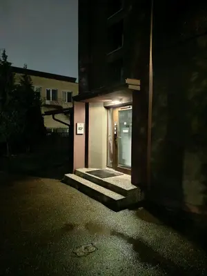 a door to a building at night with lights on at L apartamentai su nemokamu parkingu in Šiauliai