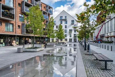 a city street with a fountain and buildings at Modern cozy apartment with free parking in trendy Paupys in Vilnius