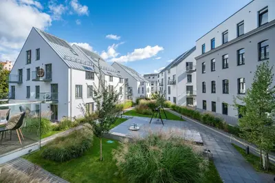 an apartment courtyard with a garden and buildings at Modern cozy apartment with free parking in trendy Paupys in Vilnius
