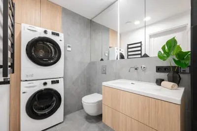 a bathroom with a washing machine and a sink at Modern cozy apartment with free parking in trendy Paupys in Vilnius