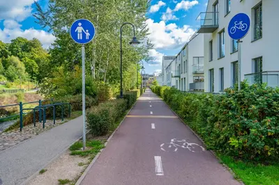 a bike path next to a building with two signs at Modern cozy apartment with free parking in trendy Paupys in Vilnius