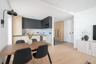 a kitchen and dining room with a wooden table and chairs at Modern cozy apartment with free parking in trendy Paupys in Vilnius