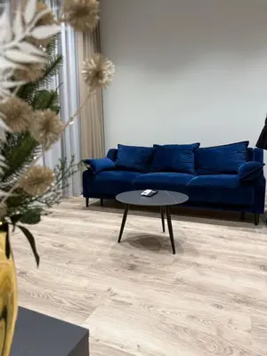 a living room with a blue couch and a table at Modern apartment near old town in Kaunas