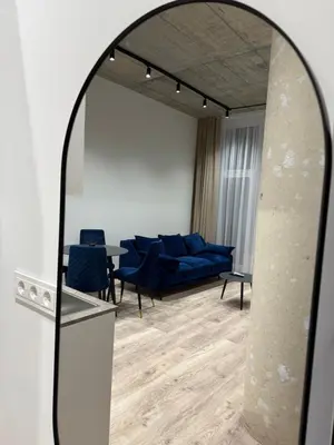 a living room with a blue couch and a mirror at Modern apartment near old town in Kaunas