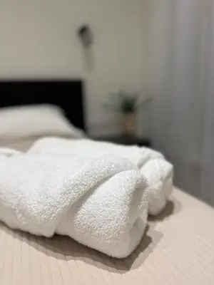 a group of white towels sitting on a bed at Modern apartment near old town in Kaunas