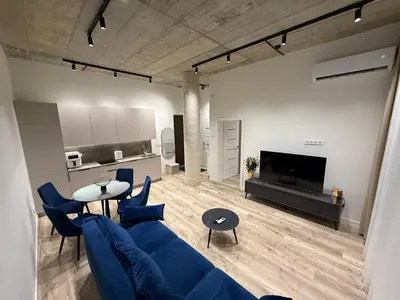 a living room with a blue couch and a tv at Modern apartment near old town in Kaunas