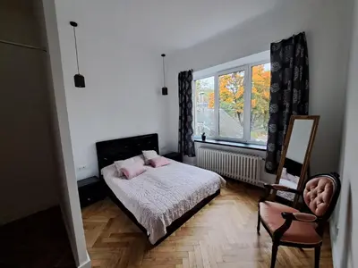 a bedroom with a bed and a window and a chair at Cathedral View Central Flat in Kaunas