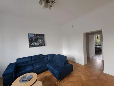 a living room with a blue couch and a table at Cathedral View Central Flat in Kaunas