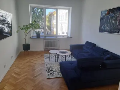 a living room with a blue couch and a table at Cathedral View Central Flat in Kaunas