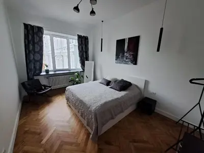 a bedroom with a bed and a large window at Cathedral View Central Flat in Kaunas