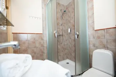 a bathroom with a shower with a toilet and a sink at OLD TOWN MARKET STAY , Self Check-in in Vilnius