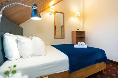 a bedroom with a bed with a blue blanket and a mirror at OLD TOWN MARKET STAY , Self Check-in in Vilnius