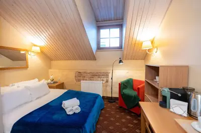 a hotel room with a bed with a blue blanket at OLD TOWN MARKET STAY , Self Check-in in Vilnius