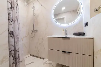 a bathroom with a sink and a mirror at ENZO Apartments in Šiauliai