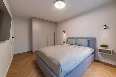 a bedroom with a large bed with blue pillows at ENZO Apartments in Šiauliai