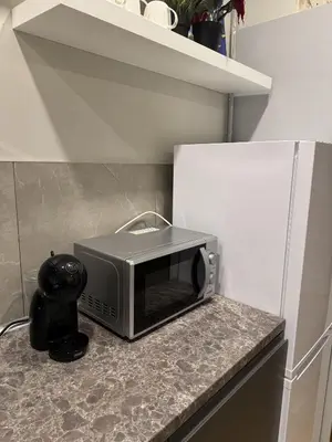 a microwave sitting on a counter in a kitchen at Gates of Dawn luxury Apartment - Aušros Vartų apartamentai in Vilnius